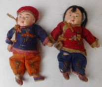 A pair of Chinese dolls: with moulded composition heads , wearing traditional costume,