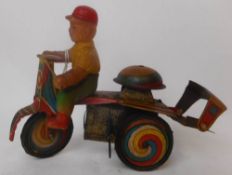 A post war, possibly Japanese tinplate clockwork tricycle:, with painted rubber driver,