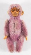 An early 20th century Schuco purple plush monkey ladies compact: with moulded face and fitted