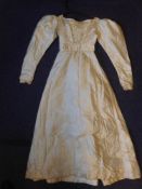A Regency period lady's ivory padded silk dress: with high waist,