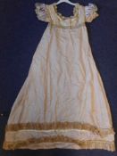A Regency period lady's silk dress: the pale pink ground with high waist, crochet edged neck,