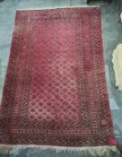 Red ground rug with repeating pattern to the central field, multi-stepped border, 296cm x 195cm