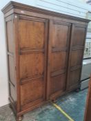 20th century oak three-door wardrobe with cavetto moulded cornice above the panelled doors, with