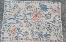 Three assorted rugs including two cream ground with foliate patterns and one small camel decorated