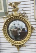 Reproduction circular mirror surmounted by eagle amongst acorns, convex plate in ball decorated