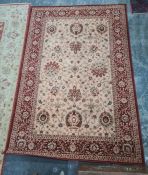 Modern machine-made cream ground rug with red foliate border, 237 x 162cm