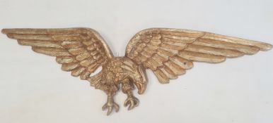 Gilt metal spread-eagle wall plaque, 109cm wide