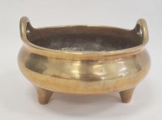 Chinese bronze censer circular, bulbous and two handled on three tab feet, 27cm diameter (four