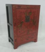 Chinese-style cabinet finished in red lacquer, with gilt decoration, two doors enclosing shelves, on