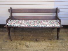 Dark wood bench with floral cushion and similar oval slatted coffee/occasional table, on straight