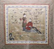 Chinese embroidered silk panel of square form depicting two ladies in a garden, within a border of