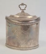 An Edwardian oval silver tea caddy with gilt interior, scroll handle, egg and dart edges, with