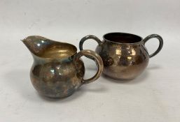 An early 20th century Japanese silver milk jug and two-handled sugar bowl, hammered detail, silver