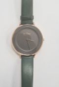 Lady's Skagen wristwatch with gilt metal and plain black matt face, on green leather strap