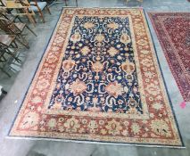 Modern blue ground rug with scrolling foliate design to the central field, stepped border, 373 x