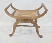 Cane seated stool on mahogany and saltire stretchered base