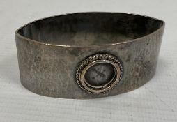 A Liberty & Co silver napkin ring, oval navette form, hammered detail (circular enamel missing),