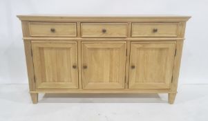 Modern oak sideboard, the rectangular top above three drawers, three cupboard doors, on square