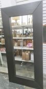 Large modern full length wall mirror of rectangular form within thick black stained wooden frame,