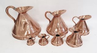 Set of seven antique graduated copper conical jug measures