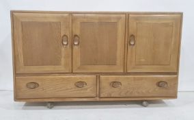 Ercol elm sideboard, the rectangular top above three cupboard doors, two drawers under, to