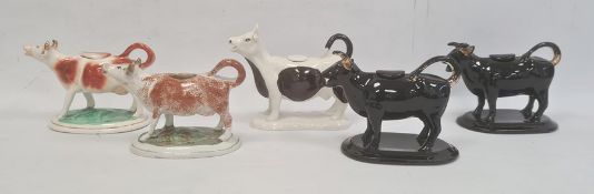 Pair Jackfield-style pottery cow creamers, black glazed and three others, various (5)