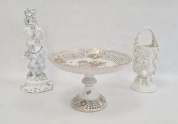 Continental porcelain figure of a girl beside floral trunk, cross swords mark to base, 26cm high,