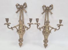 Pair of brass wall-mounted candle holders, each ribbon and putto decorated, 56cm high (2)