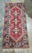 Modern Eastern-style rug, red ground with three central interlinked medallions, in creams, browns,