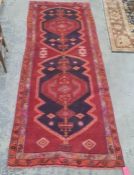 Large red ground Iranian runner, multi-coloured unique medallion design, 330 x 120cm