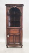 Oak corner unit, the ogee moulded top above three shelves and cupboard door below