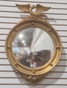 Modern convex wall mirror with gilt-effect finish, surmounted by eagle