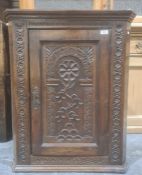 Probably 18th century wall-hanging corner cupboard with carved decoration to the door, 83cm high