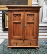 Miniature oak doll's wardrobe with two doors enclosing doll's clothes hanging space and shelves,