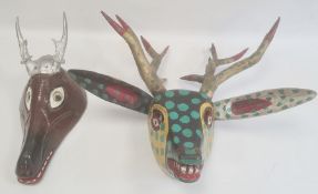 Mexican carved and painted wood stag mask in black, yellow and gold with green spots and another