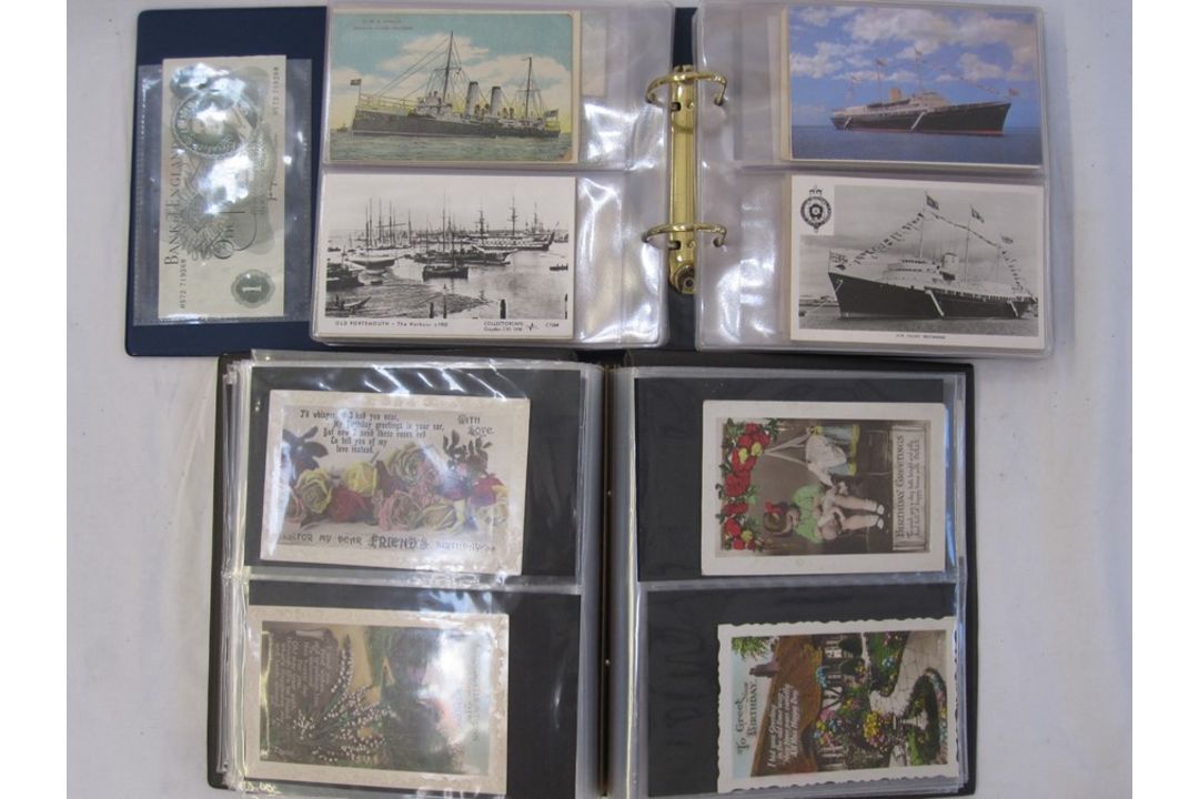 Two albums of mainly early to mid 20th century postcards, including Christmas and New Year street