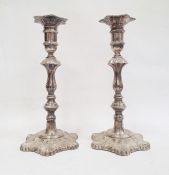 Pair of 1970's silver-mounted candlesticks with relief decoration, on quatrefoil-shaped bases and