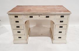 Early 20th century white painted pedestal desk, with campaign-style handles, 11 assorted drawers, on