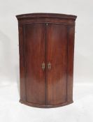 19th century mahogany bowfront wall-hanging two-door corner cupboard, 104cm high