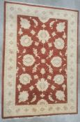 Modern Eastern-style red ground rug with foliate decoration to the central field, cream ground