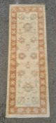Cream ground runner with foliate decoration, peach ground border, 182cm x 62cm