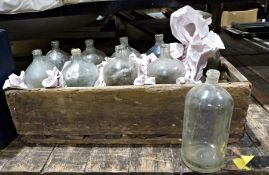 Ten vintage bottles held within a wooden carrier, probably decorative purposes only, with deliberate