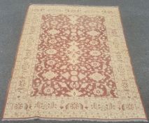 Large kilim the central field decorated with cream flowerheads on a brown ground within a wide