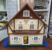 Modern wooden doll's house in the form of a chalet, with painted decoration