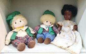 Two wind-up musical dolls with green hats and tartan outfits and an Armand Marseille black doll, the