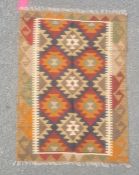 Maimana kilim rug decorated with lozenges in orange and blue on a brown ground, 113cm x 81cm.