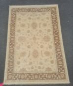 Modern rug, the central field decorated with stylised flowerheads on a cream ground, within a