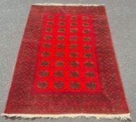 Modern Afghan rug, the central field with elephant's foot guls on a red ground with multiple