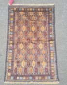 Baluchi rug, the central field decorated with brown lozenges within blue borders and within a floral