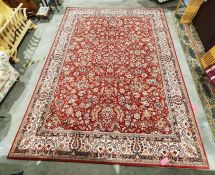 Modern red ground rug with allover foliate decoration, cream ground foliate decorated border,